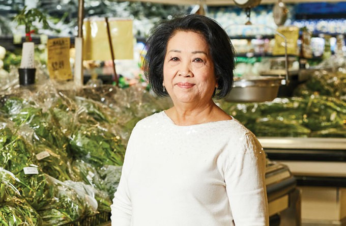 Bà Le Dam Doan đứng cạnh một quầy bán rau muống ở siêu thị, tại bang Georgia, Mỹ. Ảnh: Atlanta Magazine